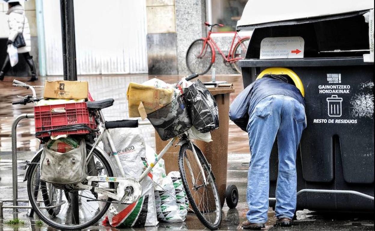 Imagen de archivo de una persona busca en un contenedor de basura. 