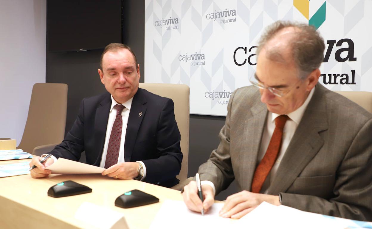 Ramón Sobremonte, director de Cajaviva Caja Rural, observa cómo Miguel Ángel Benavente, presidente de FAE, firma el convenio. 