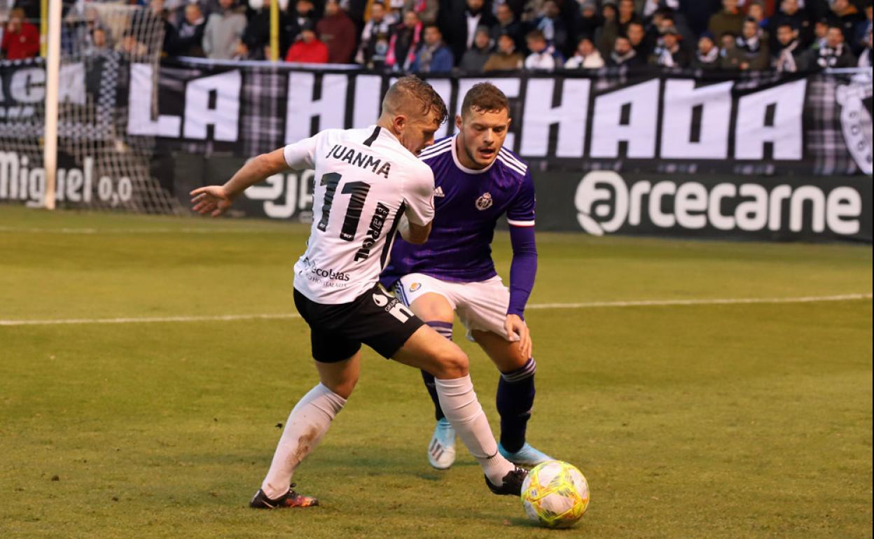 Juanma protege el balón ante la presión de Diego Alende.