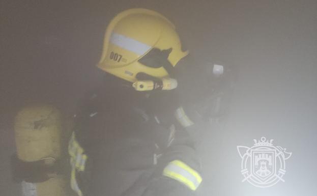 Imagen principal - Imágenes de los bomberos en el interior del bar. 