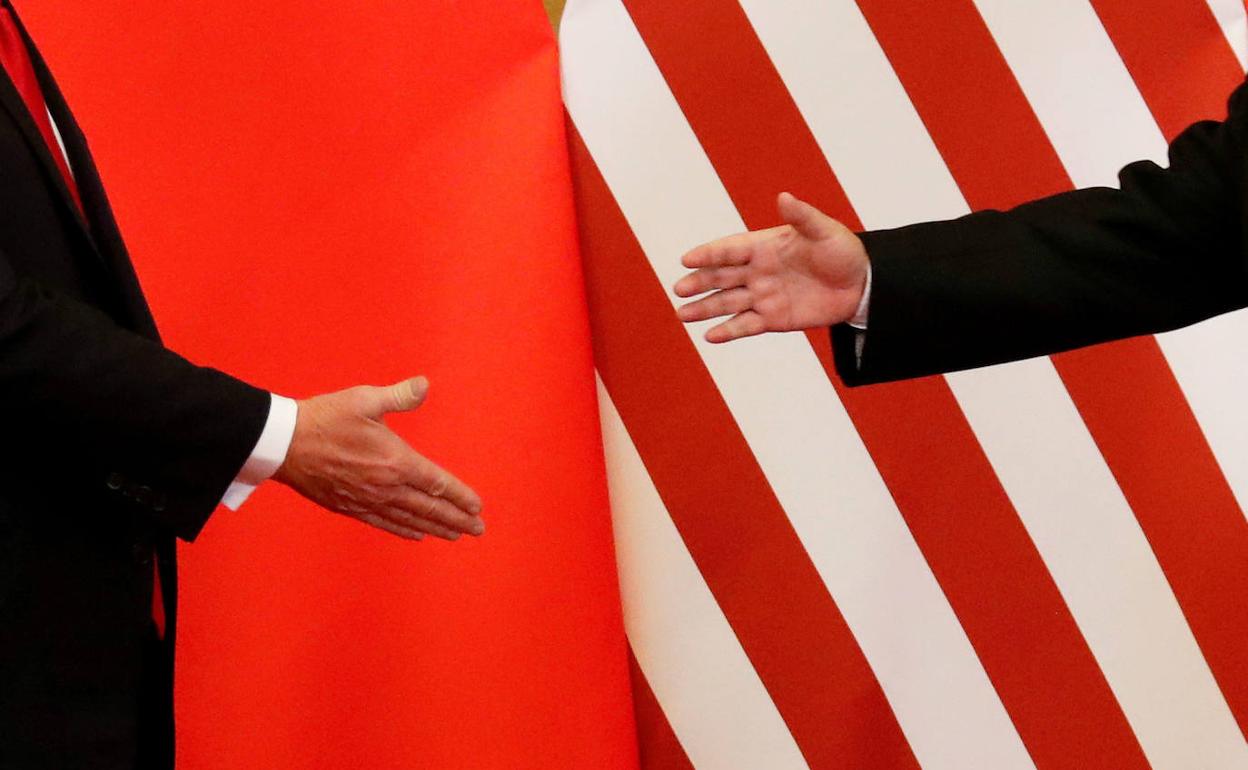 El presidente Trump y su homólogo chino Xi Jimping, se dan la mano.