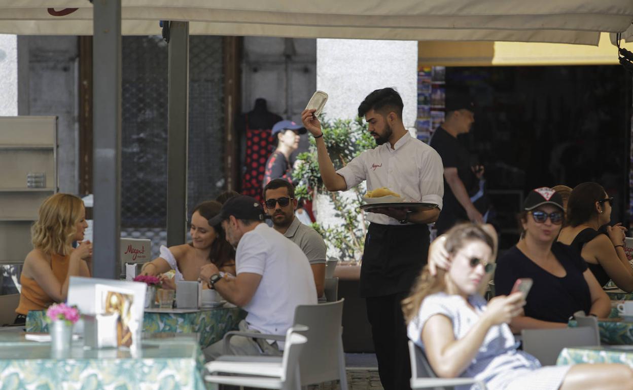 Un camarero atiende una terraza en Madrid.