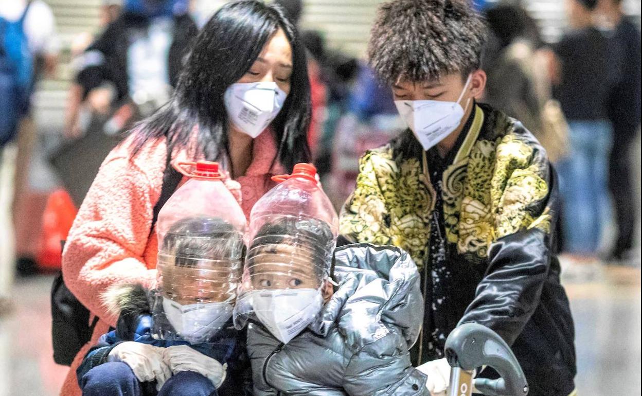 Dos niños con protecciones faciales improvisadas en el aeropuerto de Cantón (China). 