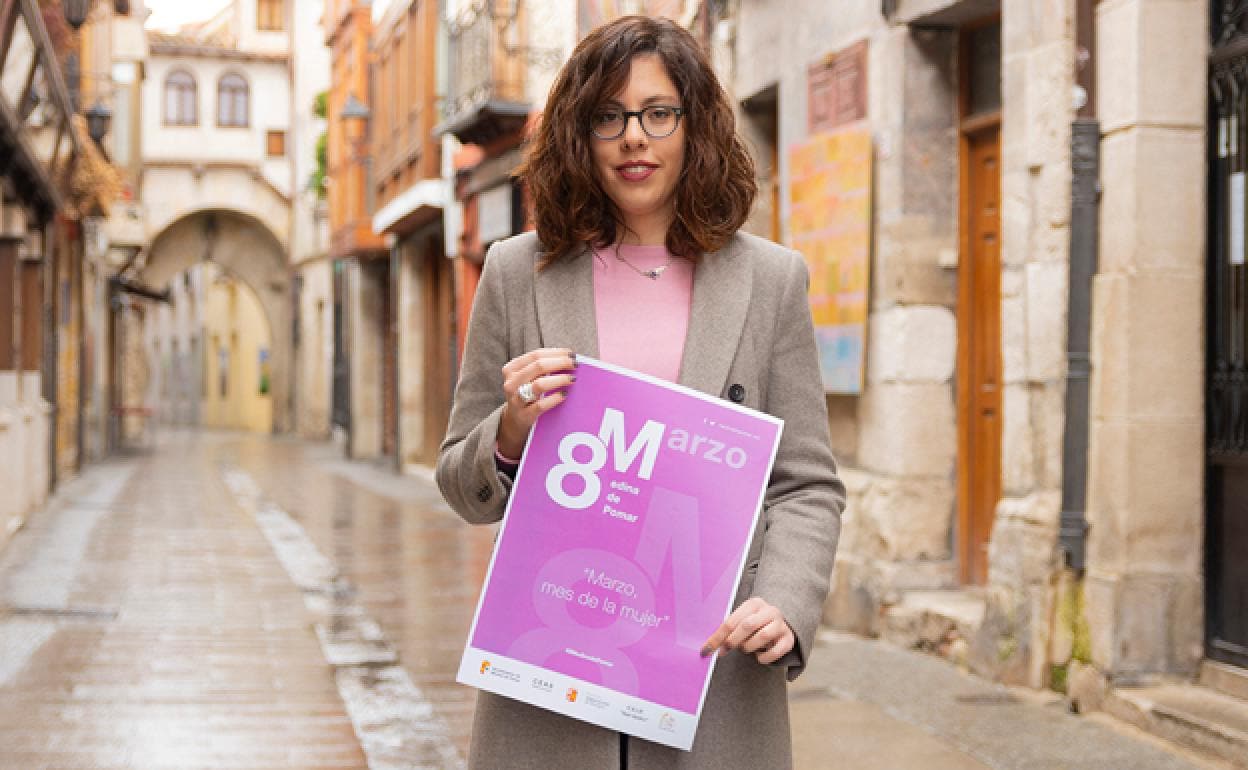 Nerea Angulo González, concejala de Igualdad dal Ayuntamiento de Medina de Pomar con el cartel de las actividades. 