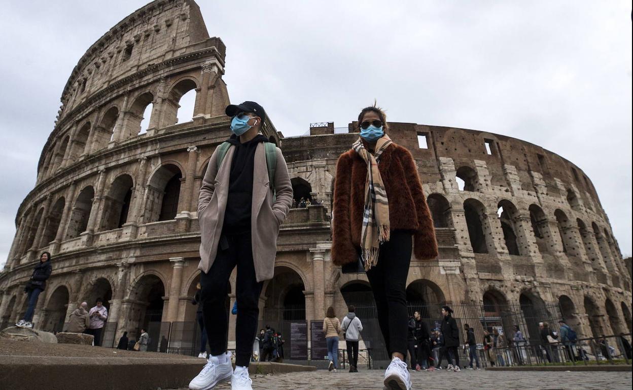 Dos turistas con mascarillas, en el Coliseo de Roma.