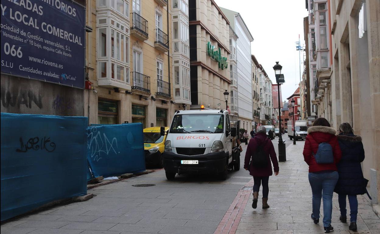 Calle Moneda, con varios vehículos de carga y descarga.