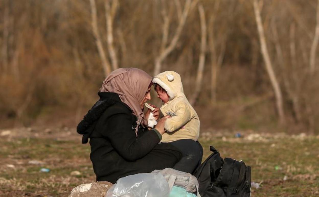 Una refugiada con su bebé cerca de la frontera turca con Grecia 