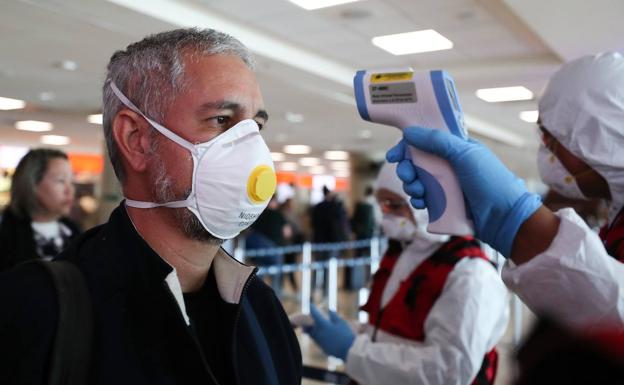 Viajero protegido por una mascarilla durante un control en un aeropuerto