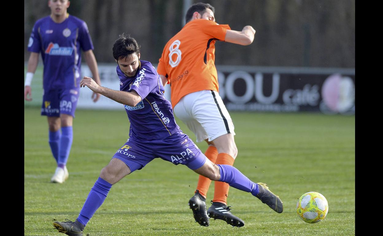 Alvarito, del Palencia Cristo, pugna por un balón ante David Herrero.