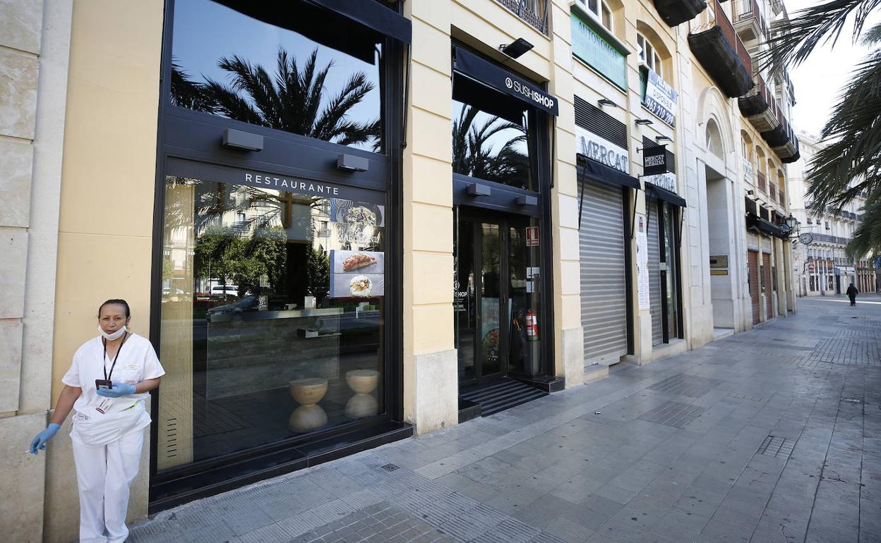 Una mujer frente a comercios cerrados en el centro de Valencia.