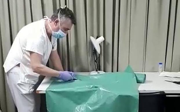 Un sanitario enseña a fabricar un delantal de protección contra el coronavirus con bolsas de plástico