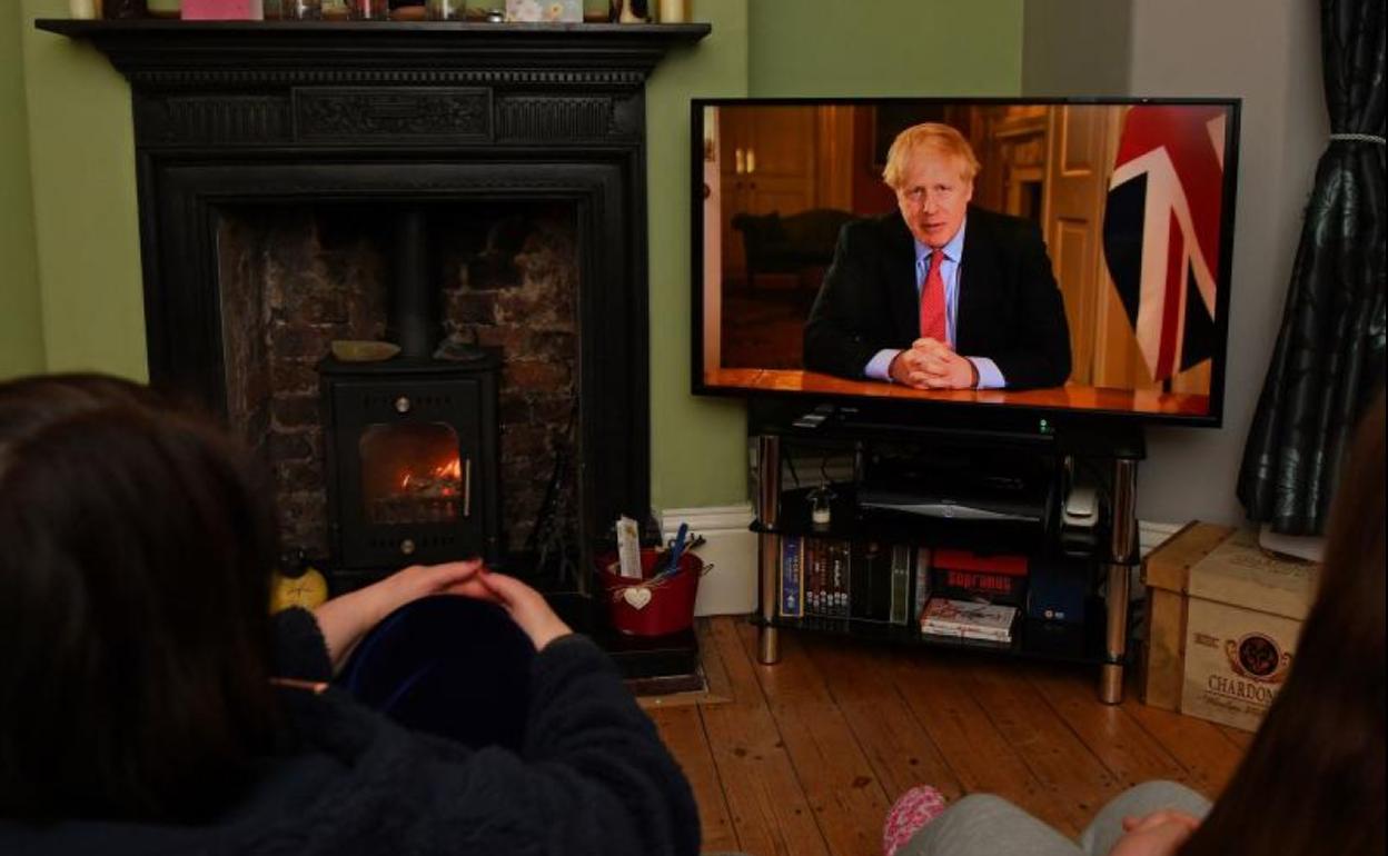 Una familia británica escucha el discurso de Boris Johnson.