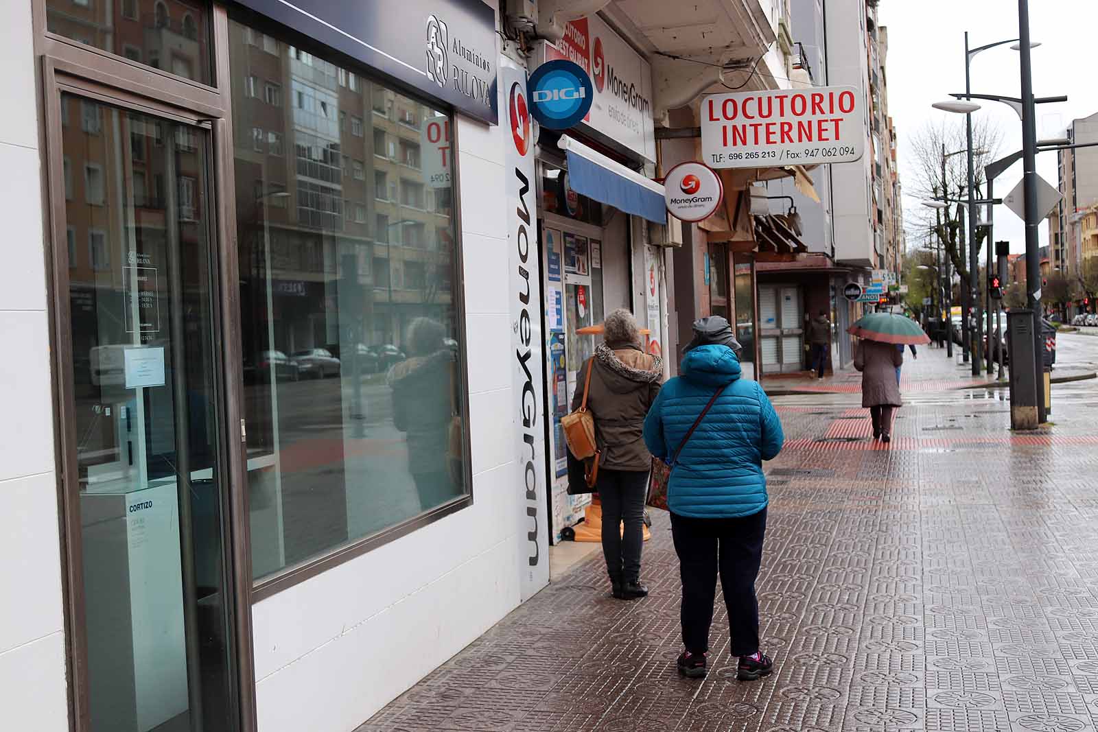 Una vecina consulta una esquela en la calle.