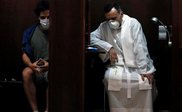 Un sacerdote administra la confesión en la Basílica de la Virgen de los Desamparados de Valencia. 