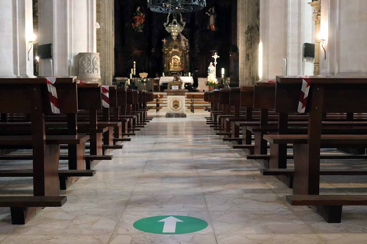 Una mujer se echa gel desinfectante a la entrada de la iglesia deSan Lesmes en Burgos. 