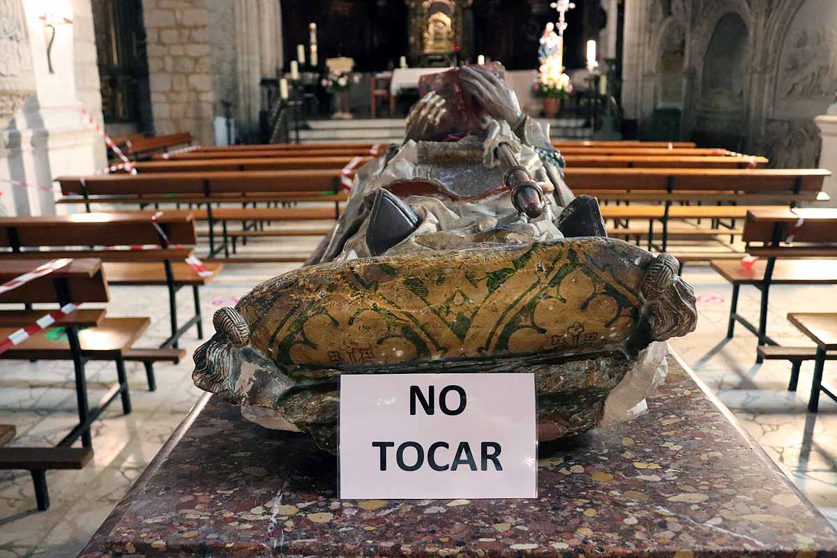 Una mujer se echa gel desinfectante a la entrada de la iglesia deSan Lesmes en Burgos. 