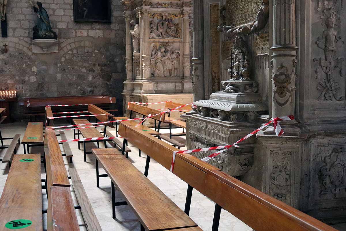 Una mujer se echa gel desinfectante a la entrada de la iglesia deSan Lesmes en Burgos. 