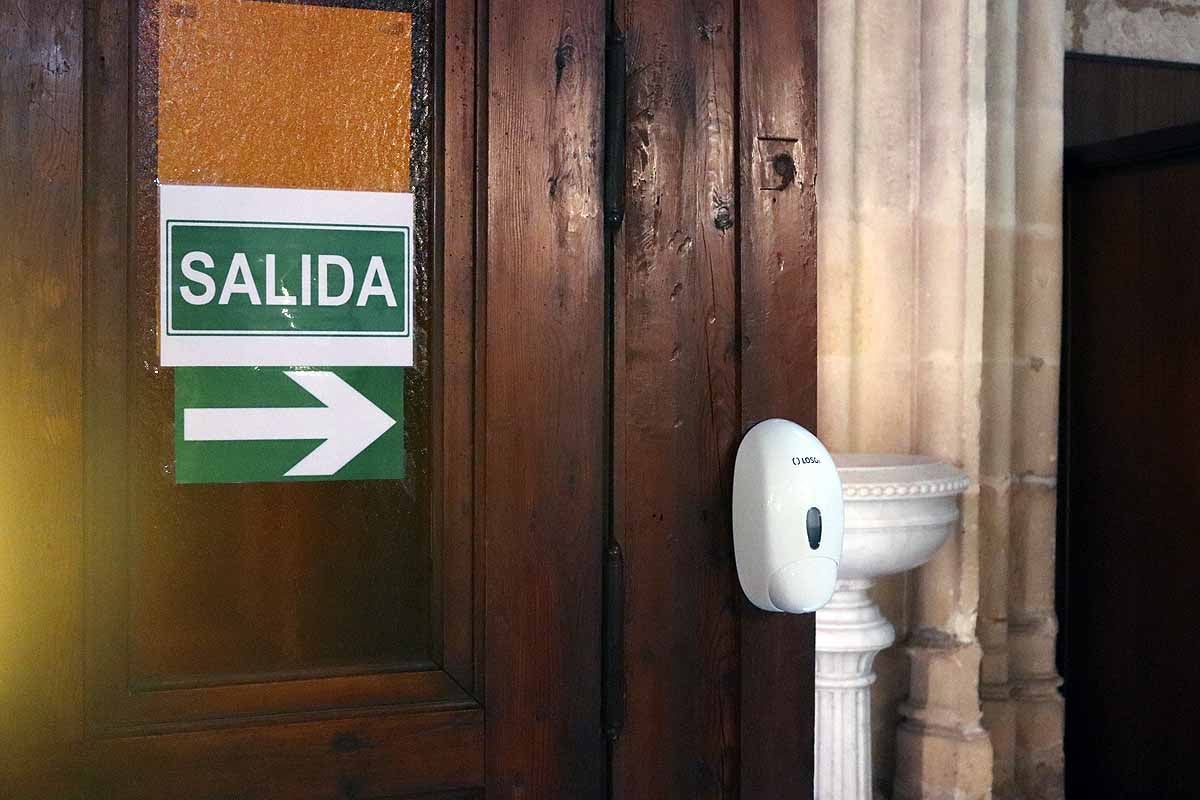 Una mujer se echa gel desinfectante a la entrada de la iglesia deSan Lesmes en Burgos. 