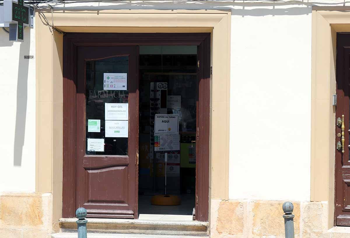 Carteles indicadores para respetar las medidas de distanciamiento en la farmacia de Quintanar de la Sierra.