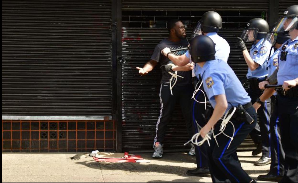 Aagentes arrinconan a un manifestante negro en Filadefia.