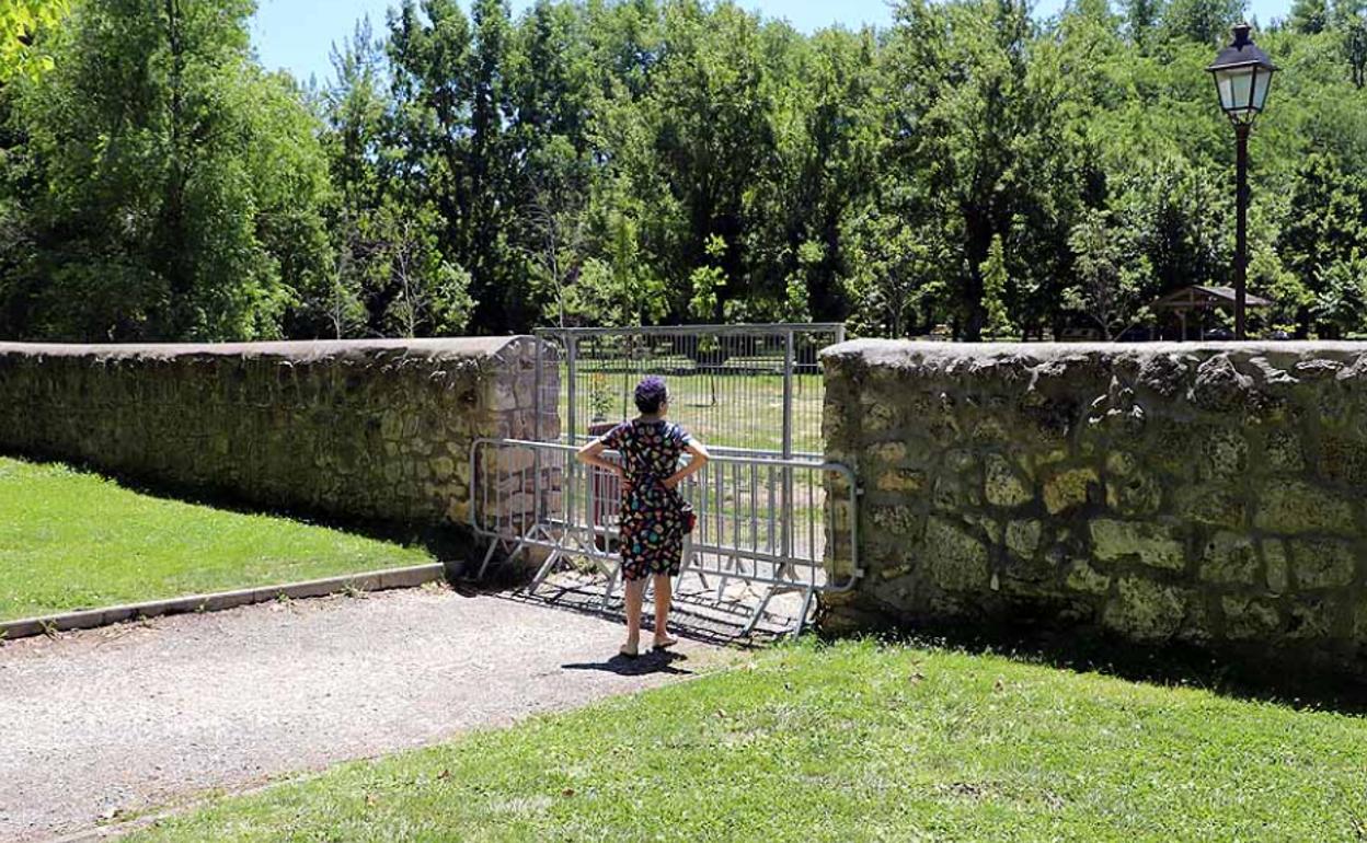 Una mujer observa El Parral cerrado y vacío. 