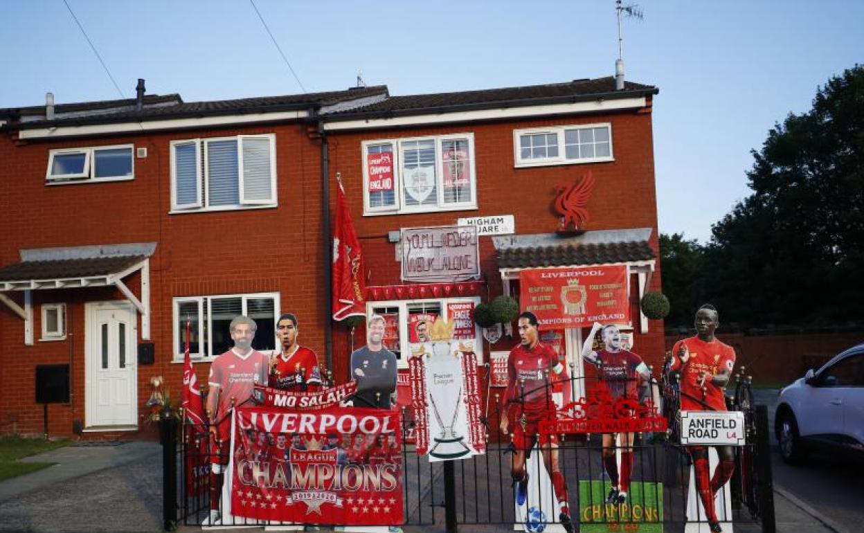 Un cartel con jugadores y el técnico del campeón a las puertas de una casa en Liverpool. 