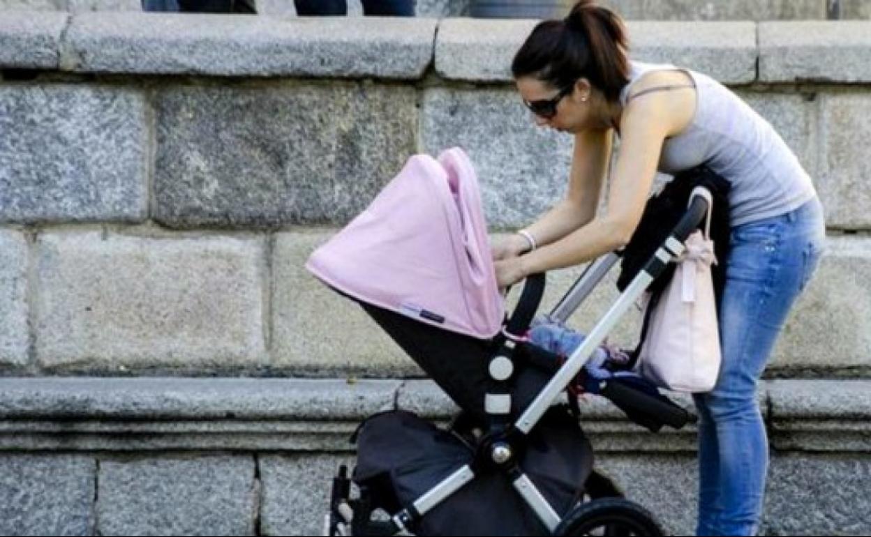 Una mujer con su bebé en un carrito.