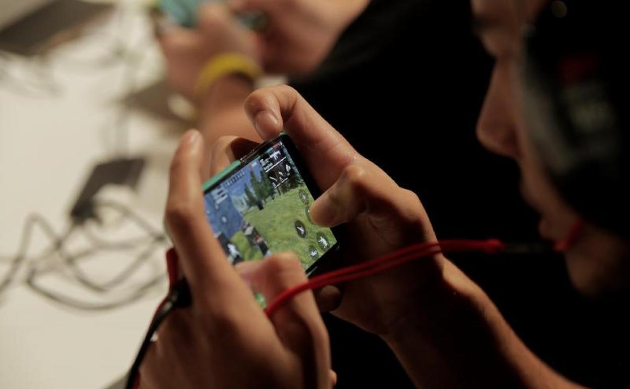 Un chico juega al telefono móvil