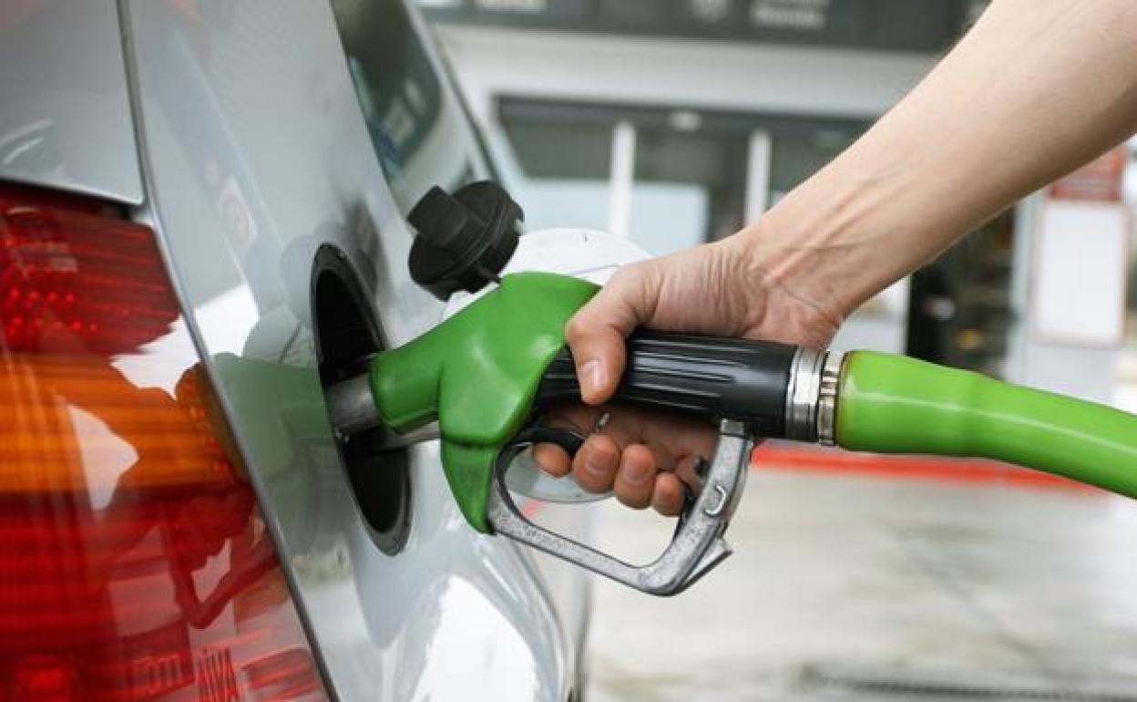 Un surtidor de gasolina trabajando en un coche.