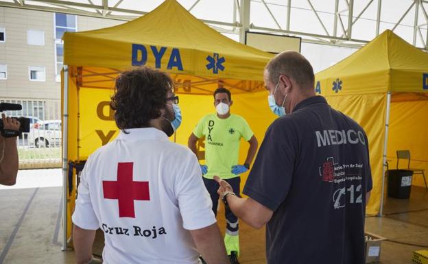 Médicos y voluntarios preparan en las inmediaciones del Instituto de Educación Secundaria de Mendillorri (Pamplona) la zona donde realizarán pruebas PCR. 