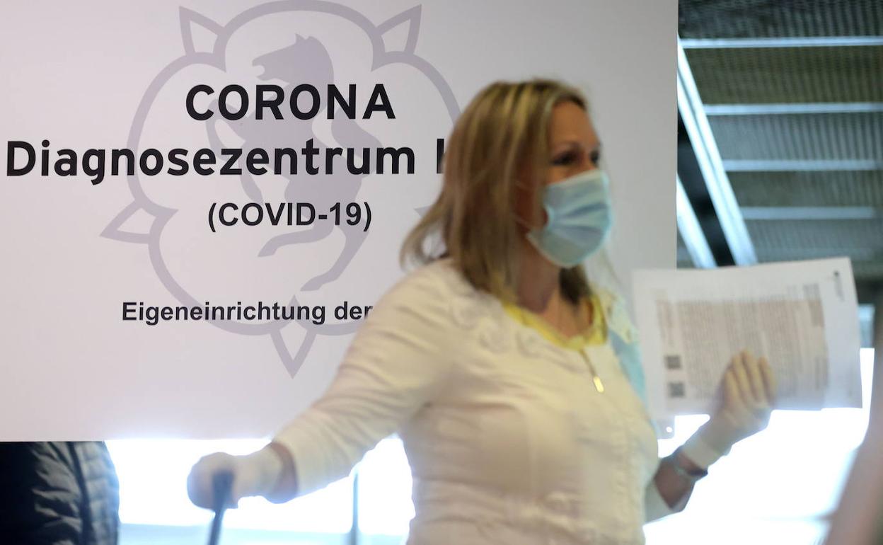 Una mujer espera para el control de Covid en el aeropuerto de Dortmund,