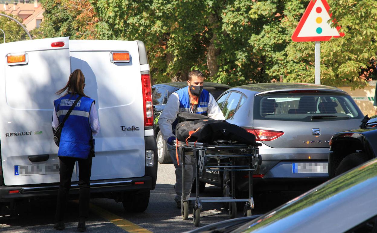 Trabajadores del servicio forense transportan el cuerpo sin vida de la mujer asesinada este sábado en La Granja. 