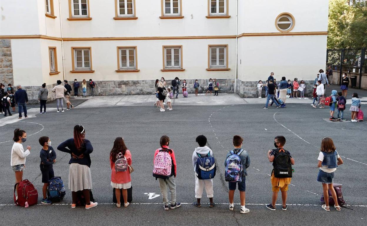 Los niños esperan en el patio de un colegio de Pamplona para entrar a clase, en el primer día del curso.