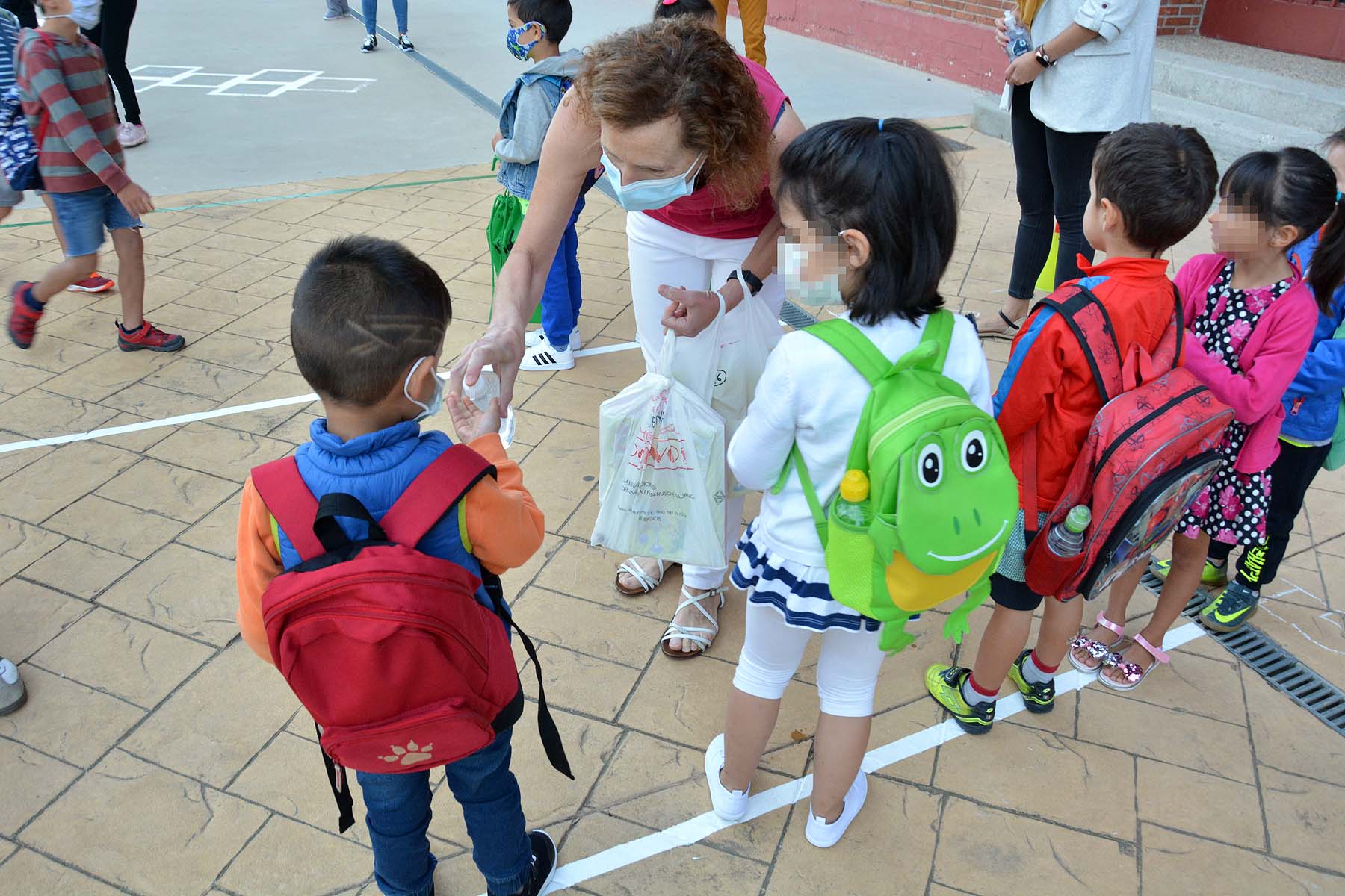 Decenas de niños esperan pacientemente en la calle antes de entrar en el colegio Jueces de Castilla. 