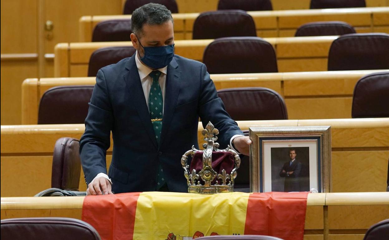 El senador del PP David Muñoz, con una bandera, una corona y la fotografía del Rey para recibir a Pablo Iglesias en el pleno del Senado.