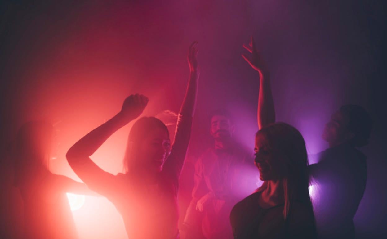 Chicas bailan en una discoteca. 