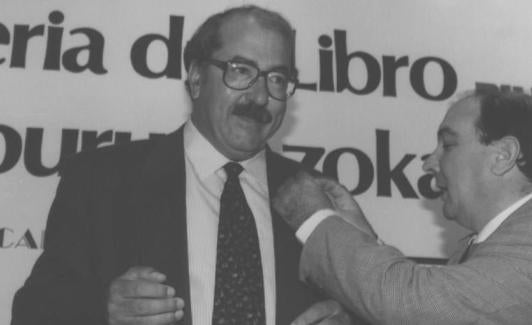 El periodista que fue de El Norte Manu Leguineche recibe una insignia en la Feria del Libro de Bilbao de 1995.