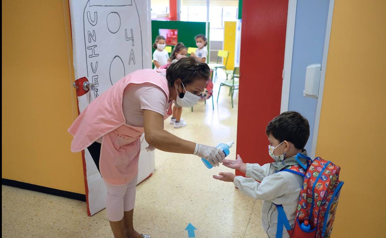 Un niño se hecha gel hidroalcohólico antes de entrar al aula.