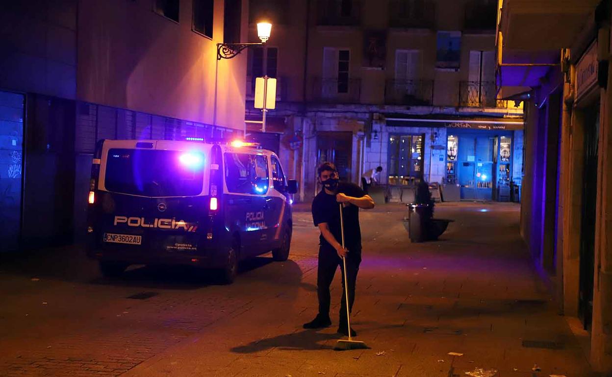 Un hostelero recoge la terraza de una bar durante el toque de queda.