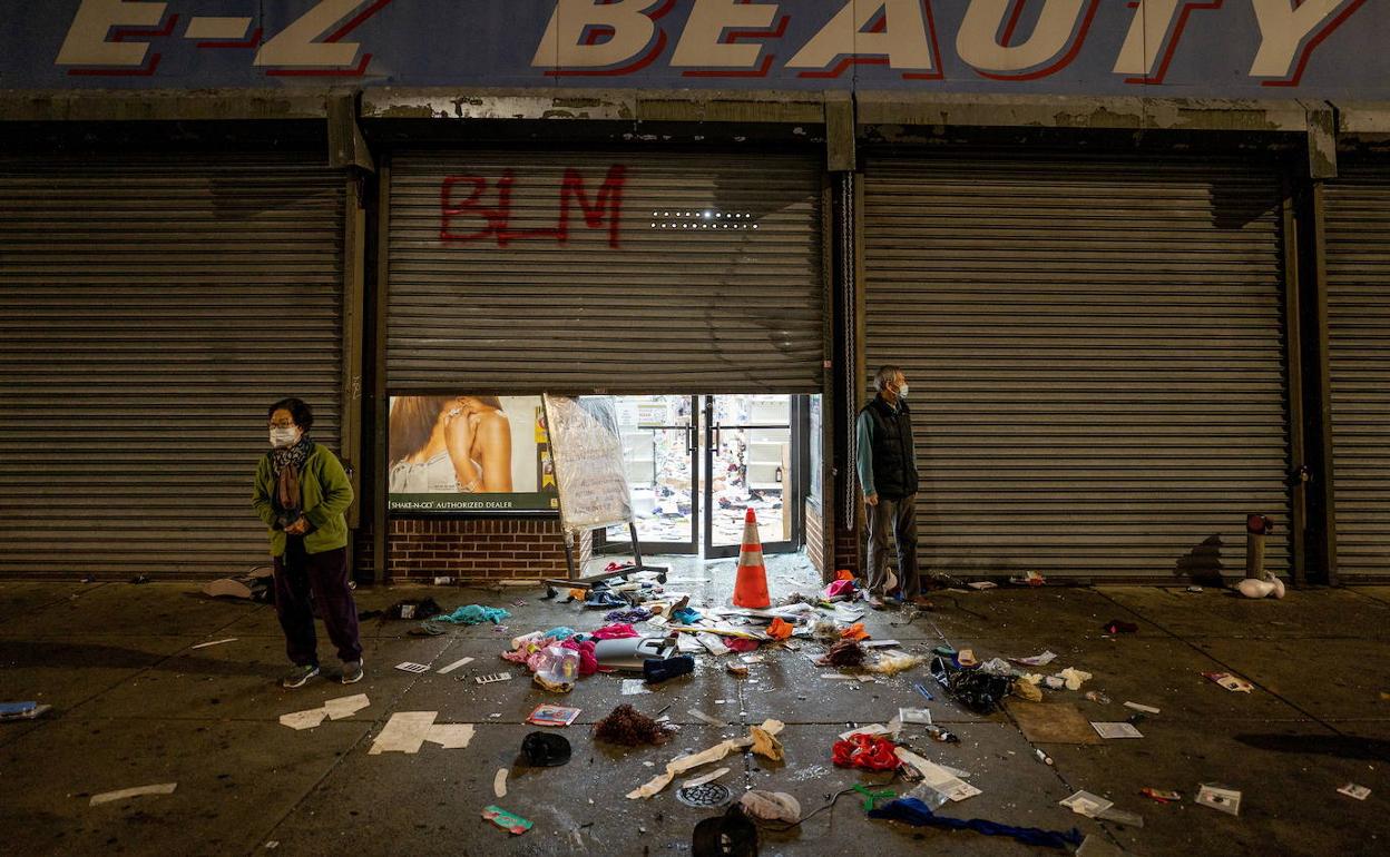 El dueño de un comercio de Filadelfia observa los destrozos causados tras ser saqueado su local.