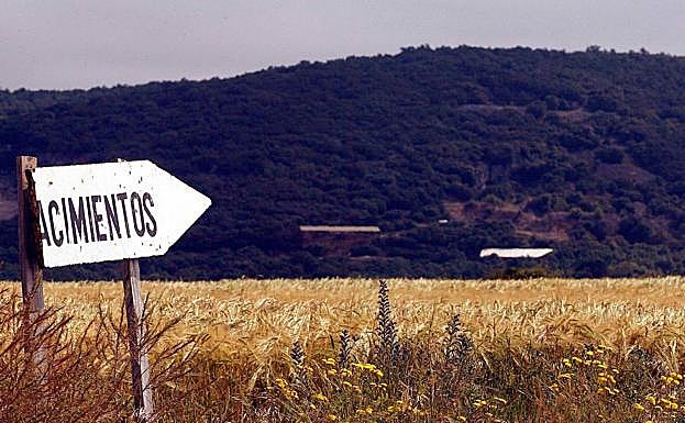Foto angitua de un cartel que señala en la imagen hacia los yacimientos ubicados en la sierra de Atapuerca. 