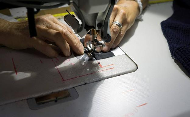 Una mujer teje un bañador fabricado a partir de redes de pesca.