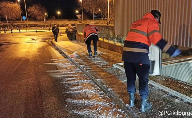 Imagen principal - Voluntarios de Potección Civil acondicionan el pavimento helado para evitar accidentes en Burgos.