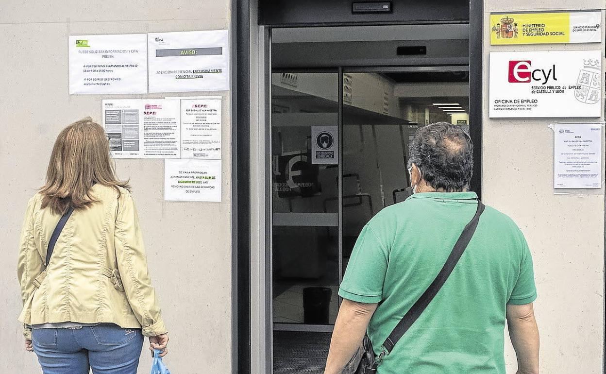 Dos personas frente al Ecyl en la Plaza del Poniente de Valladolid.