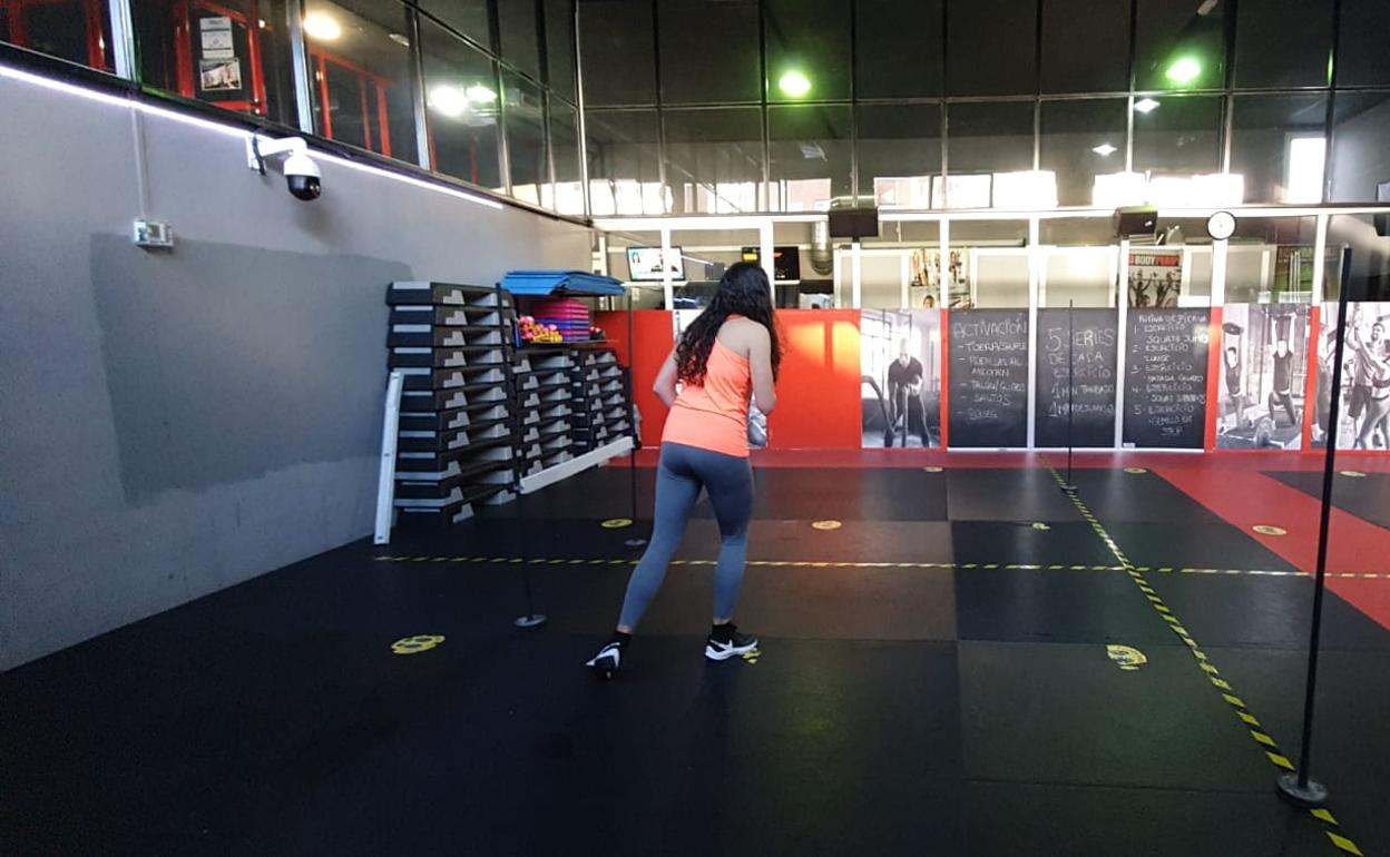 Interior de un gimnasio con las zonas delimitadas para guardar la distancia física.