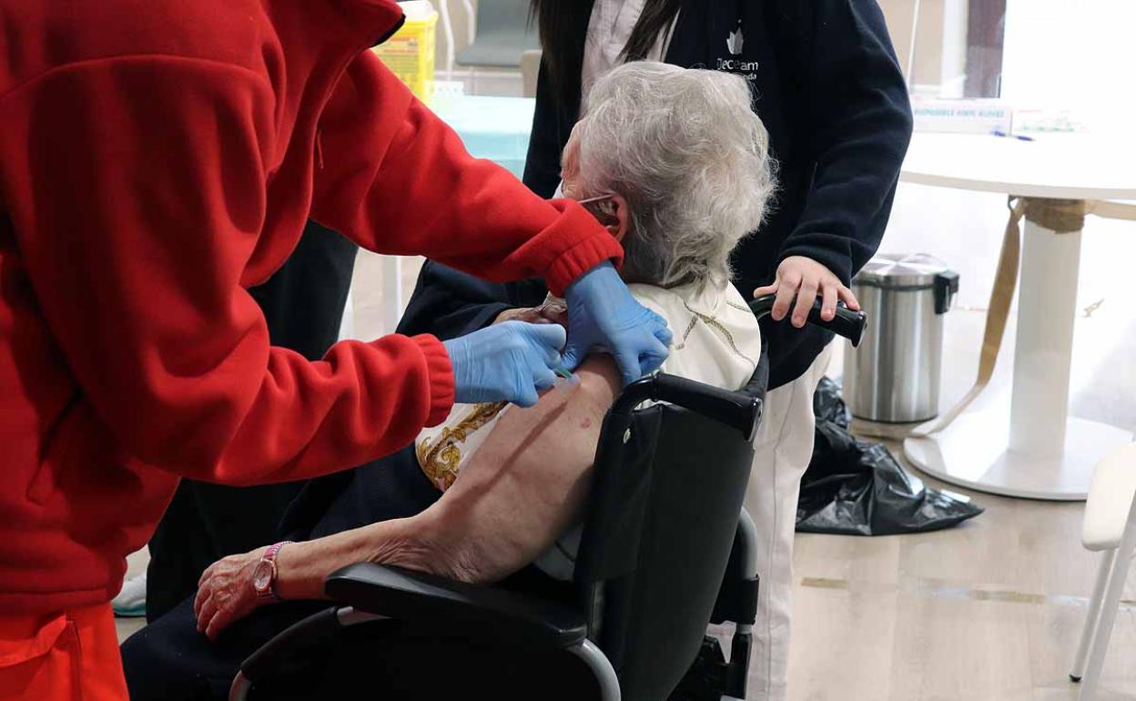 Una residente de una residencia de ancianos de Burgos recibe la vacuna contra la covid-19.