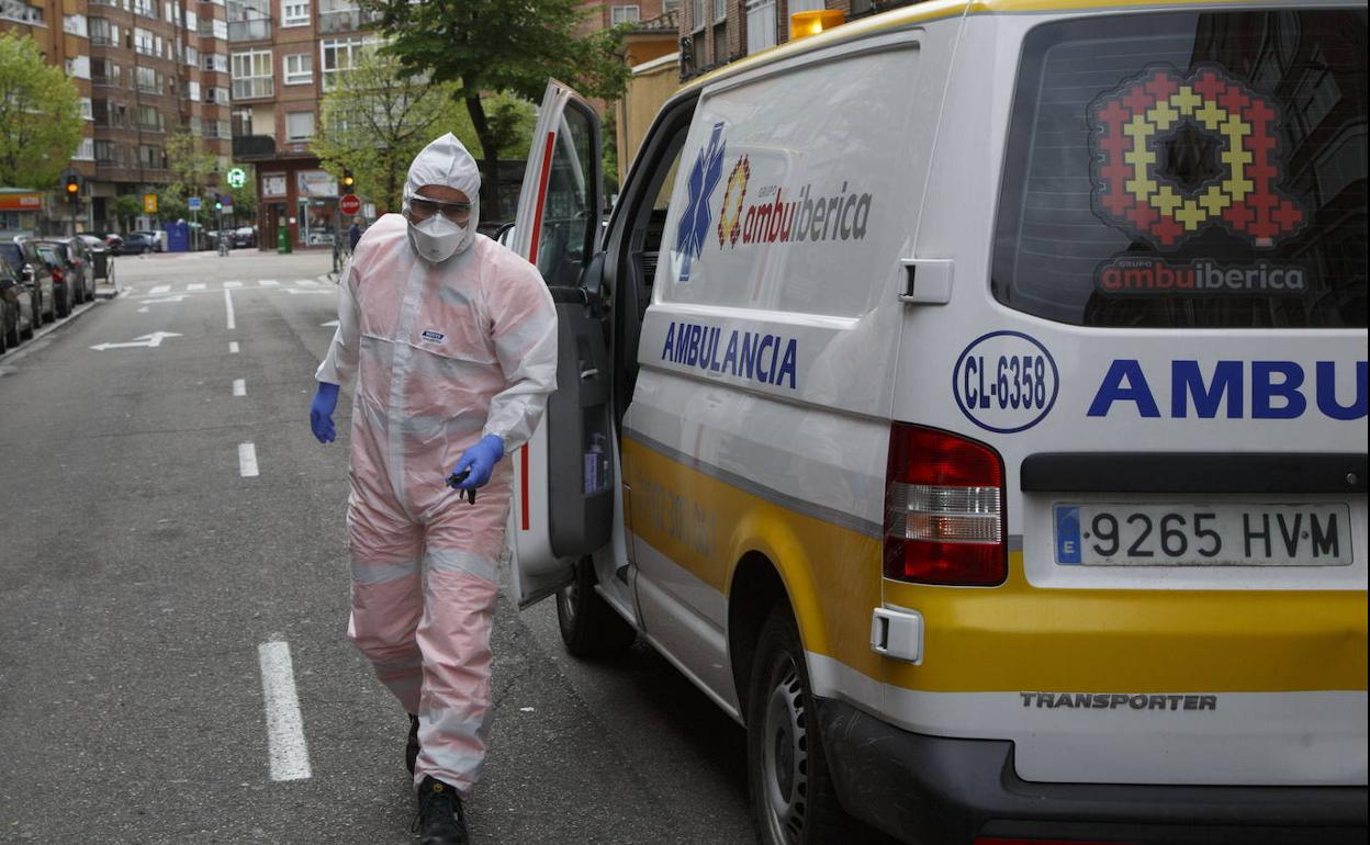 Un técnico de ambulancia traslada a un paciente con covid. 