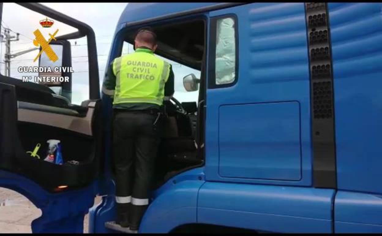 Un agente de la Guardía Civil de Tráfico inspecciona el camión. 