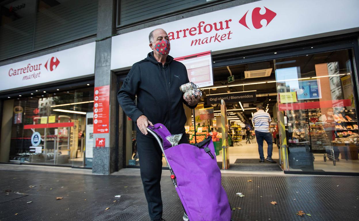 Un hombre en la puerta de un supermercado Carrfour en Bilbao.