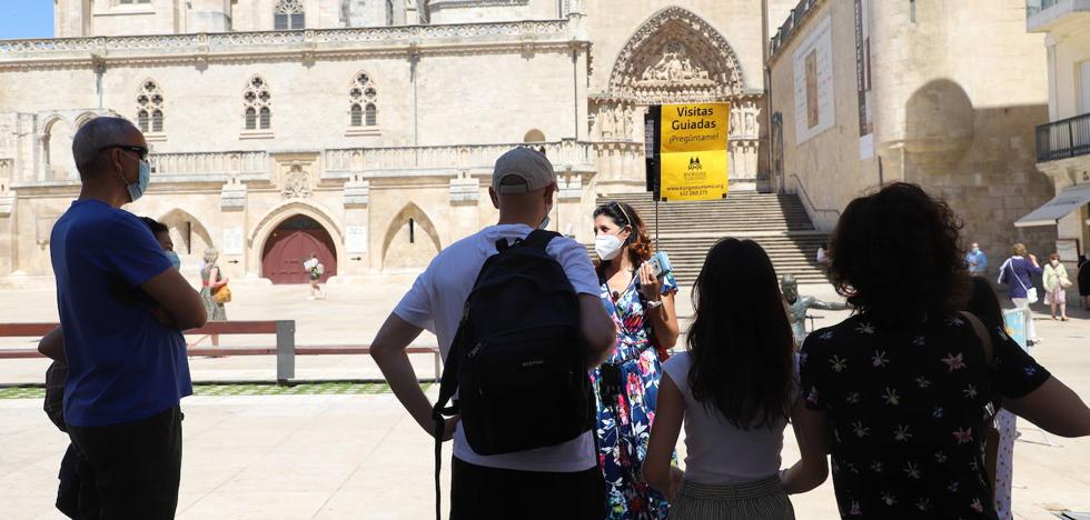 Una guía turística explica a un grupo la historia de la Catedral de Burgos.